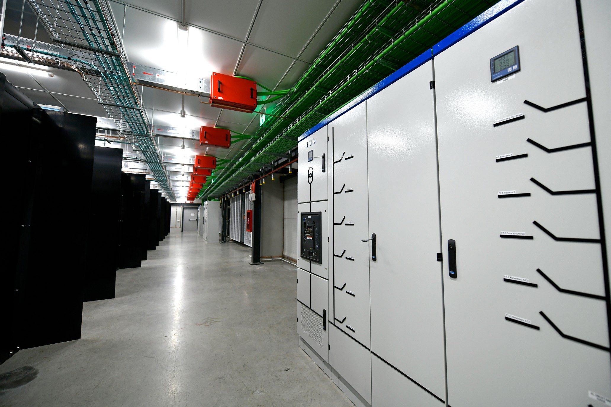 Inside EvoDC-2: black rack rows, grey LV switchboards, green cable trays and red junction boxes