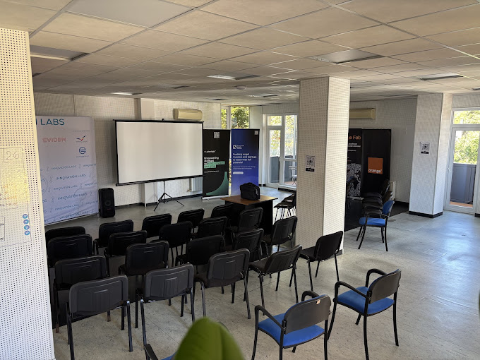 Founders Hive event room with rows of chairs, a projector screen and partner banners
