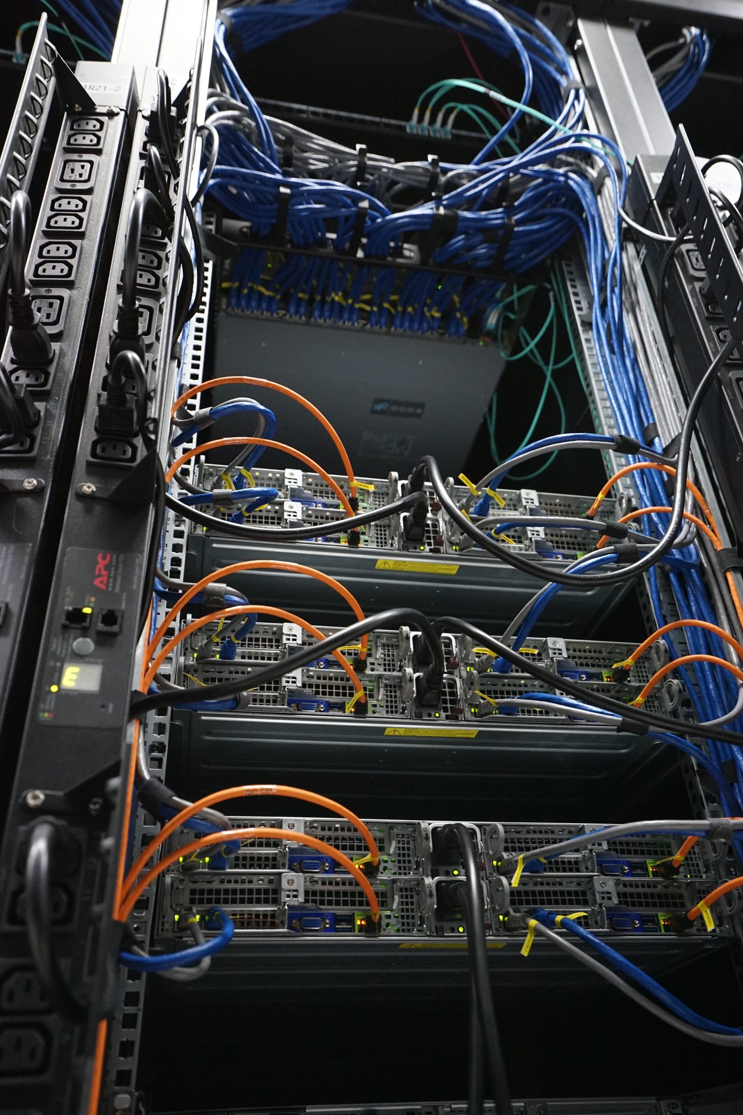 Rear of a rack: APC PDUs, servers and structured blue and orange cabling
