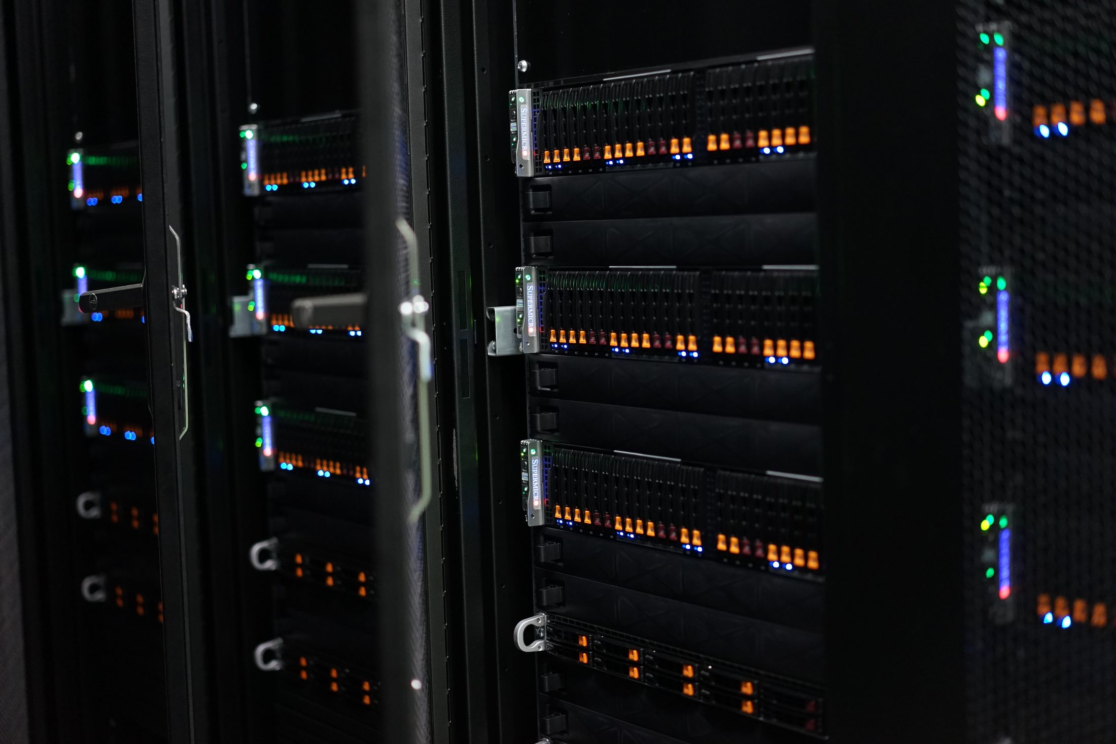 Row of racks with Supermicro servers, orange drive LEDs
