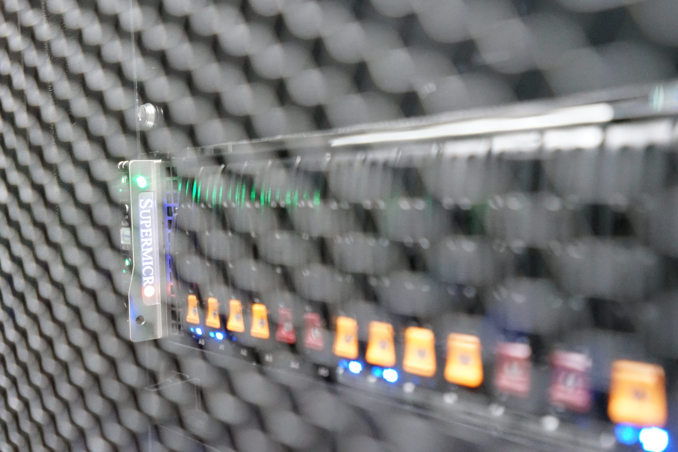 Close-up of a Supermicro server through a mesh rack door